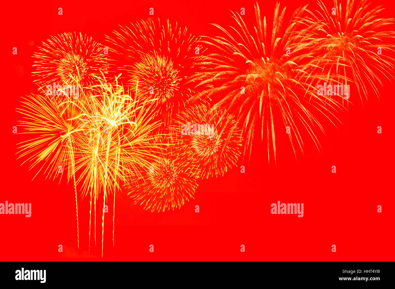 Fuegos artificiales de oro sobre fondo rojo. Foto de stock