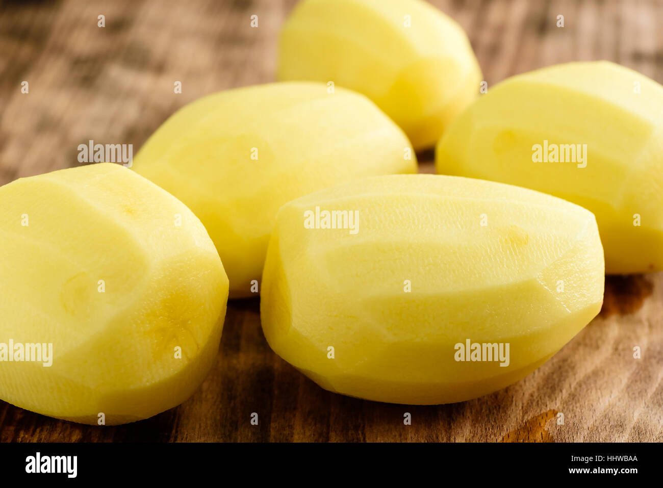 Húmedo y materias patatas peladas en placa de madera Foto de stock