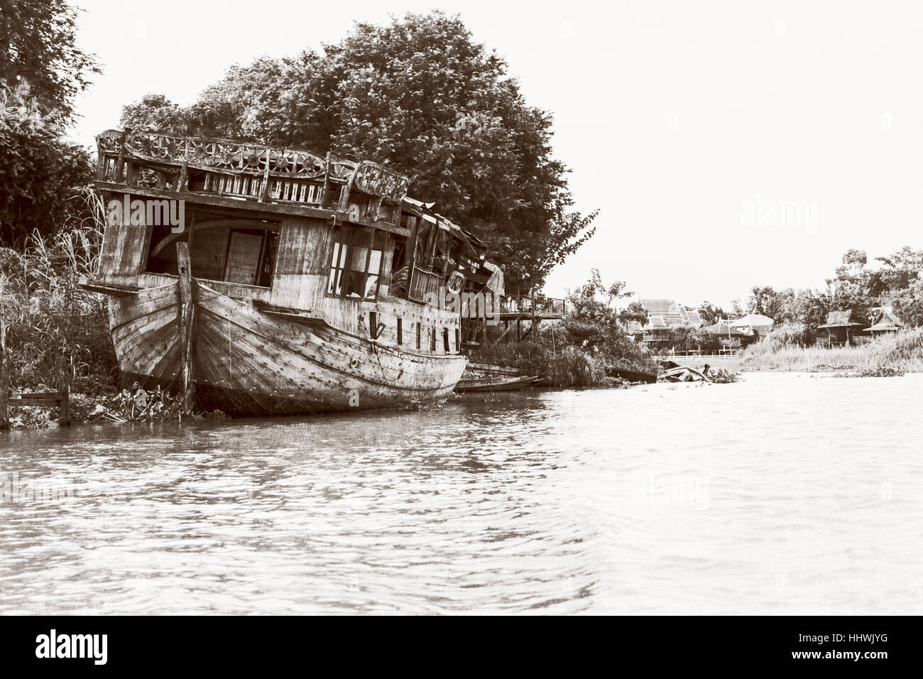 Fotografía en blanco y negro agregar textura vintage estilo del viejo barco de madera dañado varado en la orilla del mar para el fondo en Phra Nakhon Si Ayutthaya Foto de stock