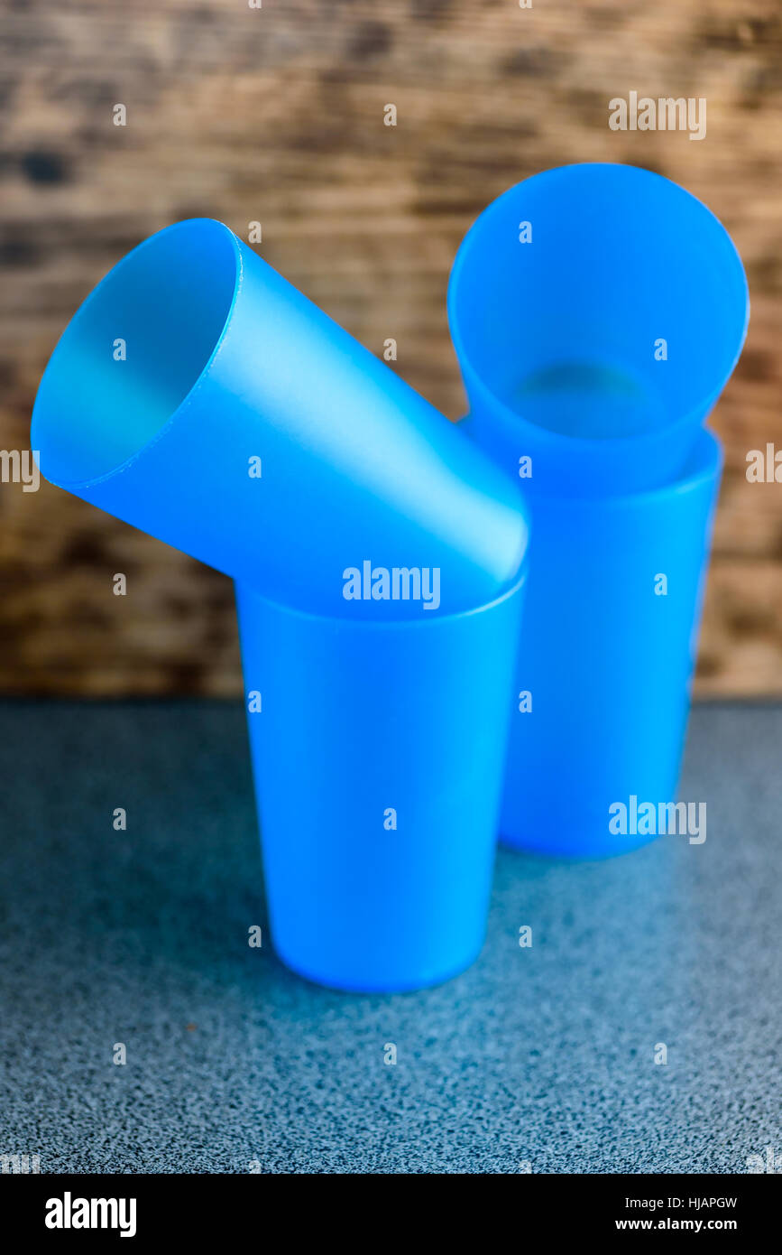 Cuatro tazas de plástico azul vacía sobre una encimera Foto de stock