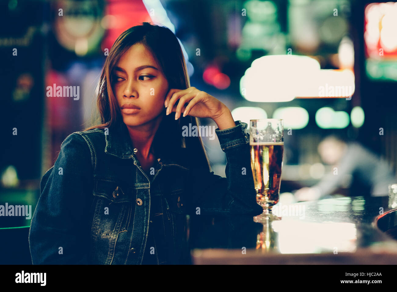 Vida nocturna, adulto chica esperando en el bar bebiendo bear Foto de stock