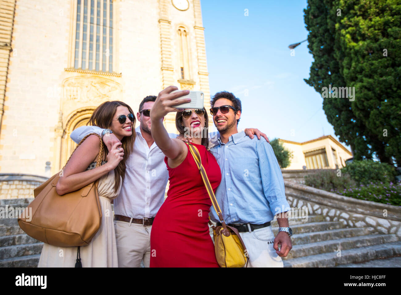Dos parejas de turistas tomando selfie en frente de la iglesia, Calvià, Mallorca, España Foto de stock
