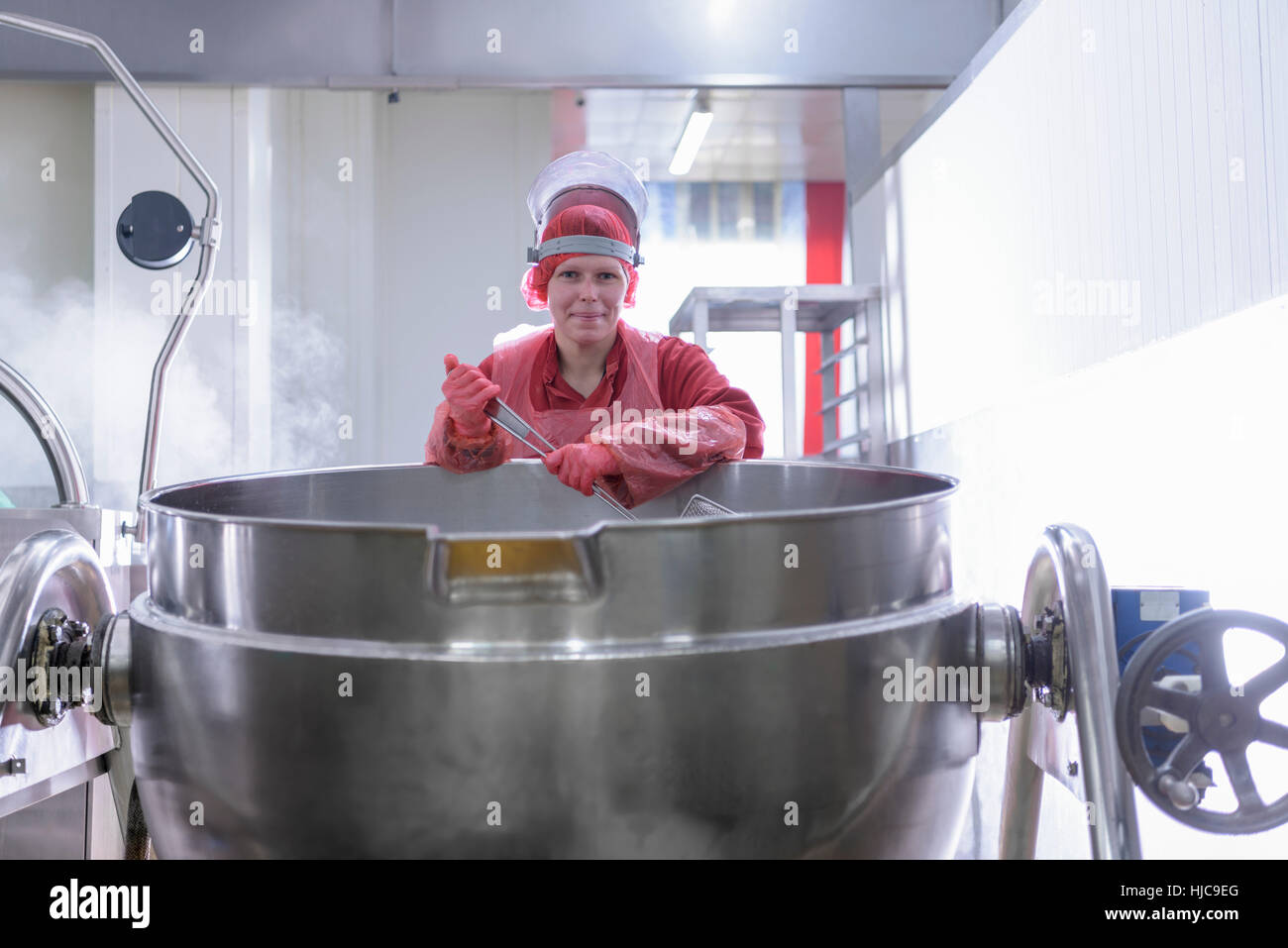Trabajadora en la zona de cocción de la comida asiática factory Foto de stock