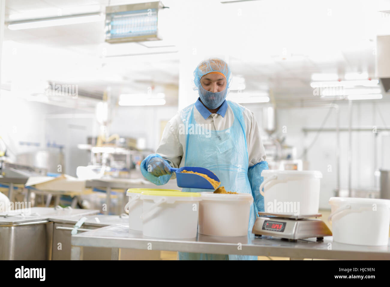 Trabajador masculino pesando curry en polvo en la fábrica de alimentos asiáticos Foto de stock