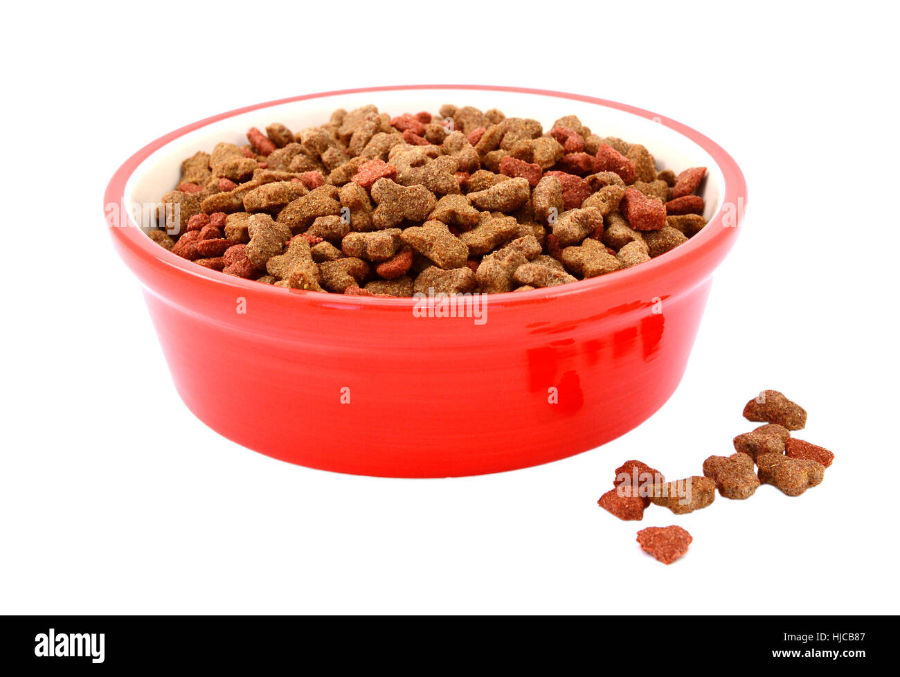 gatos seca en un recipiente de color rojo, algunas galletas derramado junto, aislado en un fondo blanco Fotografía de stock - Alamy