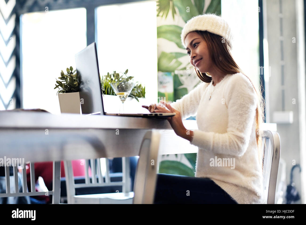 Hermosa niña redes en un café con ordenador portátil Foto de stock