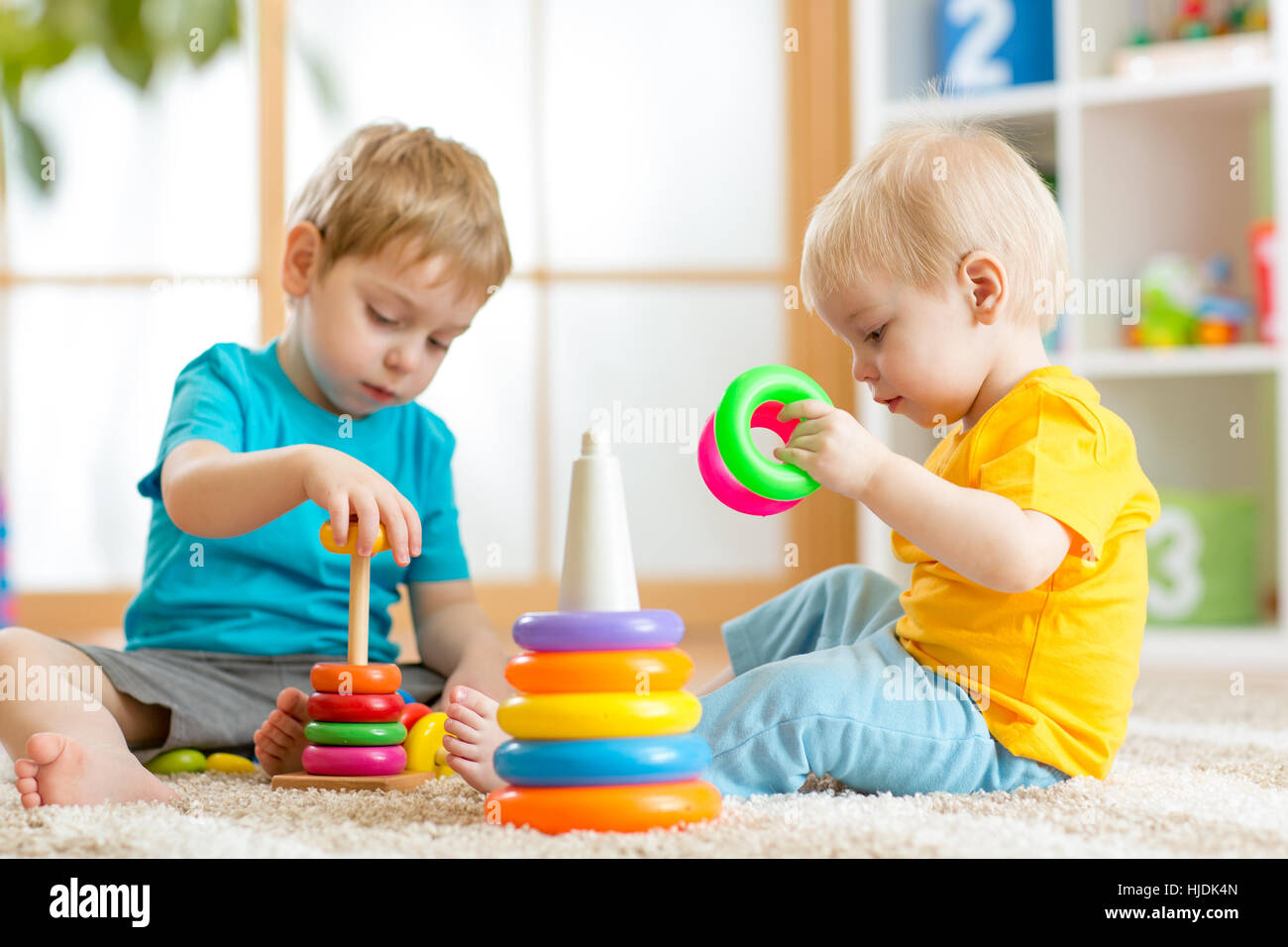 Niños jugando juntos. Niño niño y bebé jugar con bloques. Juguetes  educativos preescolares para niños de kindergarten. Amigos chicos construir  pirámide en casa o en la guardería Fotografía de stock - Alamy