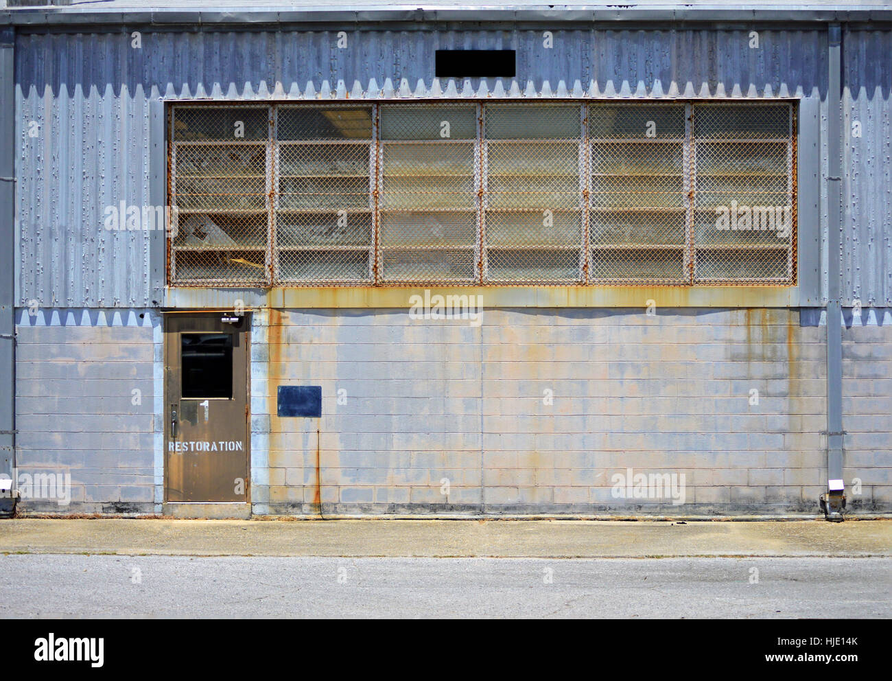 Un viejo edificio industrial oxidado con revestimiento exterior de metal y  bloques de cemento Fotografía de stock - Alamy