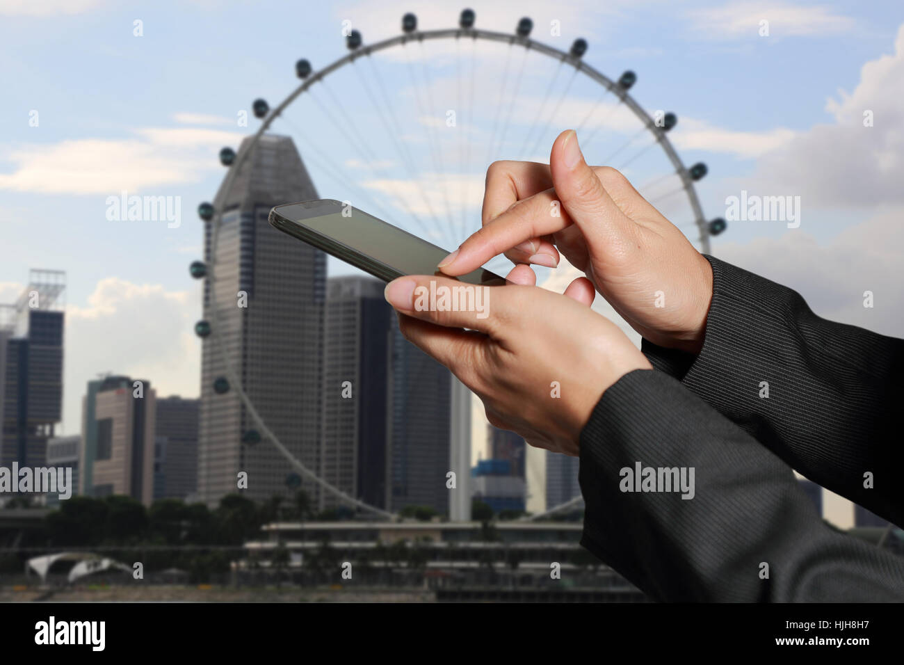 Mujer mano pantalla táctil teléfono inteligente, móvil en la ciudad de fondo abstracto borrosa. Foto de stock