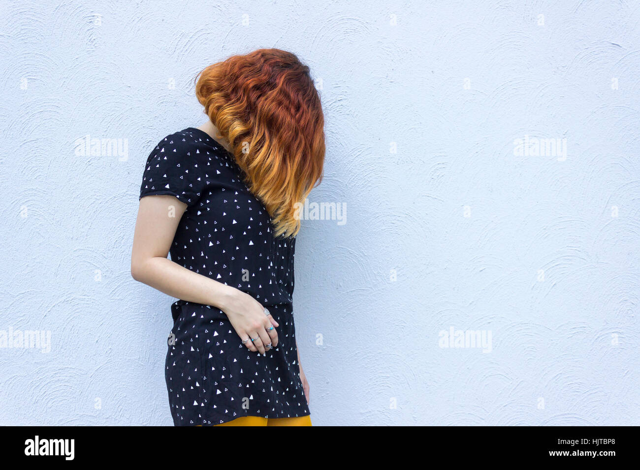 Jovenes Mujeres Caucasicas Con Pelo Corto Rojo Vestidos De Traje Negro Esta Contra La Pared Gris Con El Rostro Cubierto Fotografia De Stock Alamy