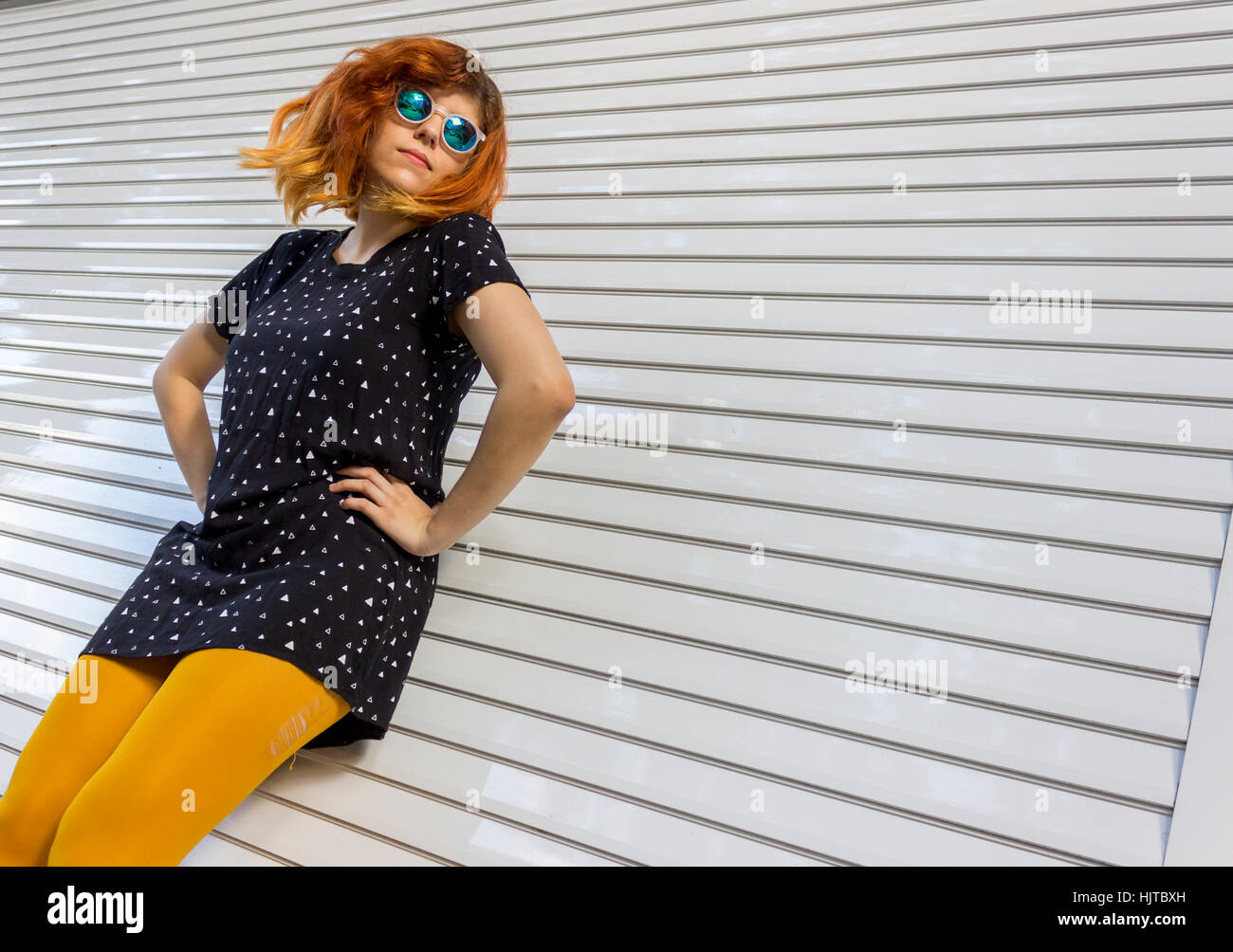 Mujeres caucásicas vestidos de traje negro, amarillo medias y gafas de sol está juguetón contra la pared blanca Fotografía de stock - Alamy Mujeres caucásicas vestidos de traje negro, amarillo medias y gafas de sol está juguetón contra la pared blanca Fotografía de stock - Alamy