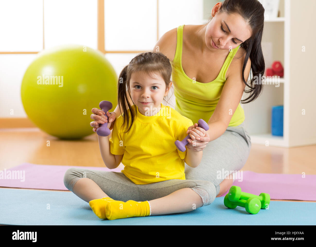 Hija de madre y niño participar en fitness pesas Foto de stock