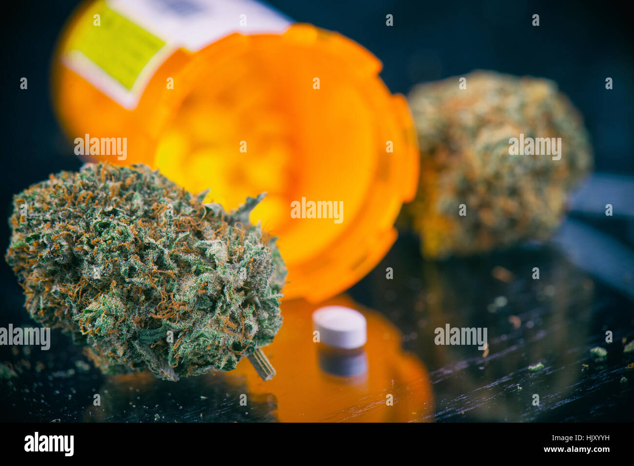 Detalle de brotes de cannabis y prescripciones píldoras más de superficie reflectante - Concepto de dispensario de marihuana medicinal Foto de stock