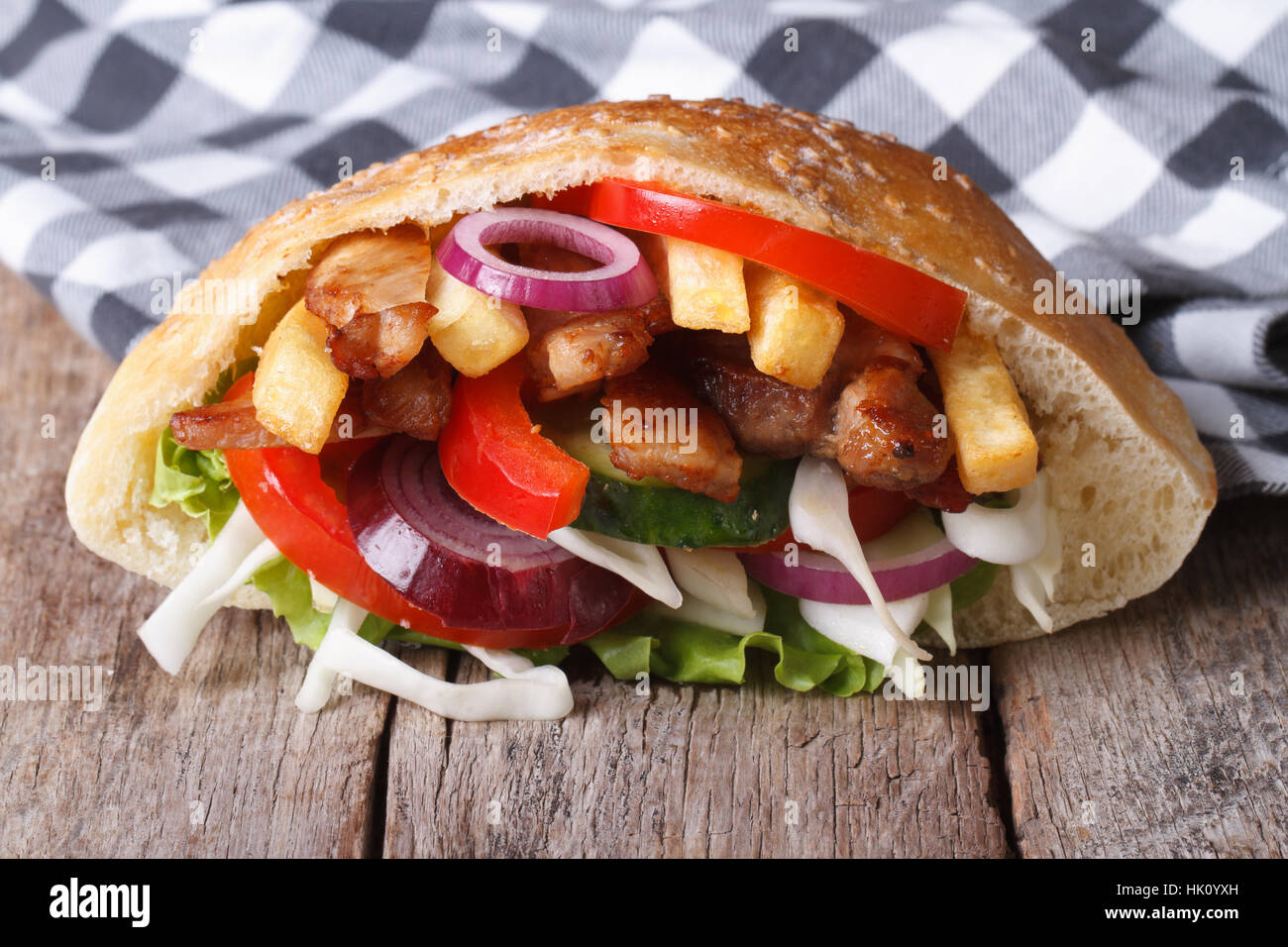 Delicioso kebab con carne, verduras y patatas fritas en pan de pita closeup horizontal Foto de stock