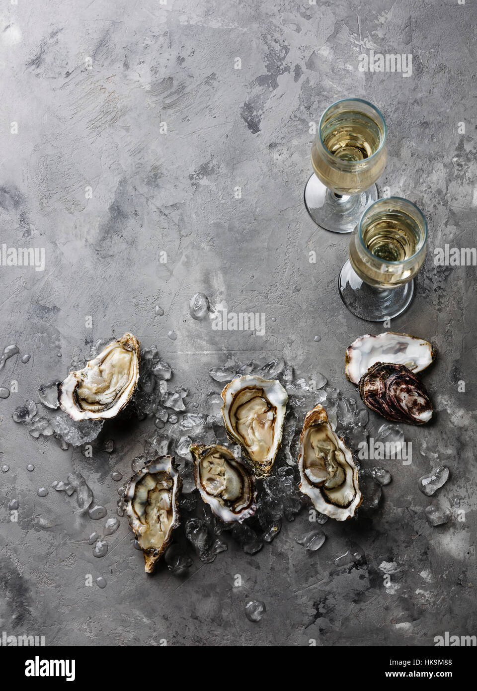 Abrir las ostras y champagne en la textura del fondo de cemento gris espacio de copia Foto de stock