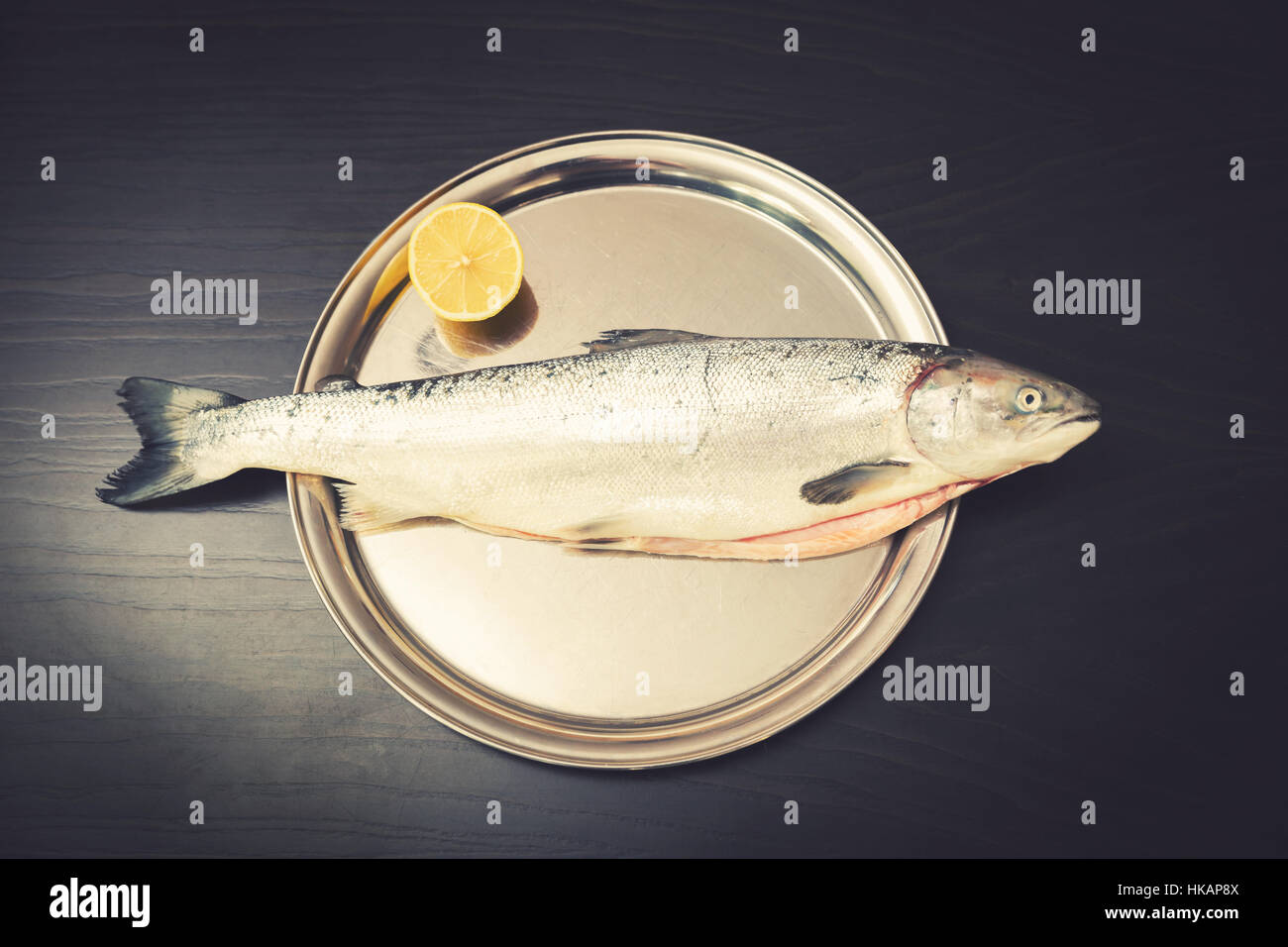 Pescado salmón con limón sobre la bandeja de metal Foto de stock