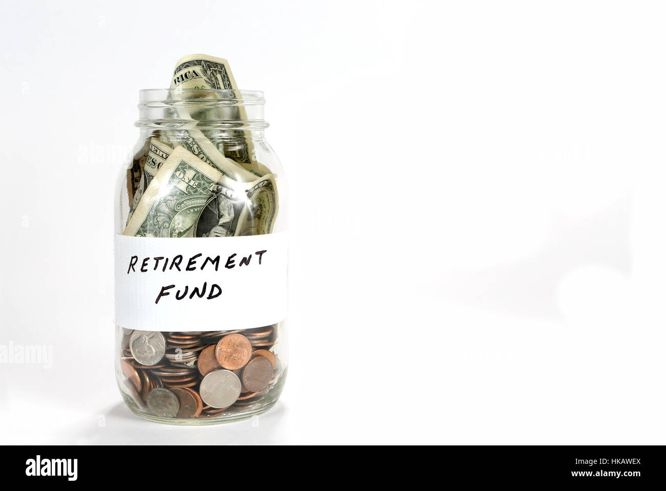 Una jarra de vidrio transparente tiene dinero para el fondo de jubilación. Foto de stock