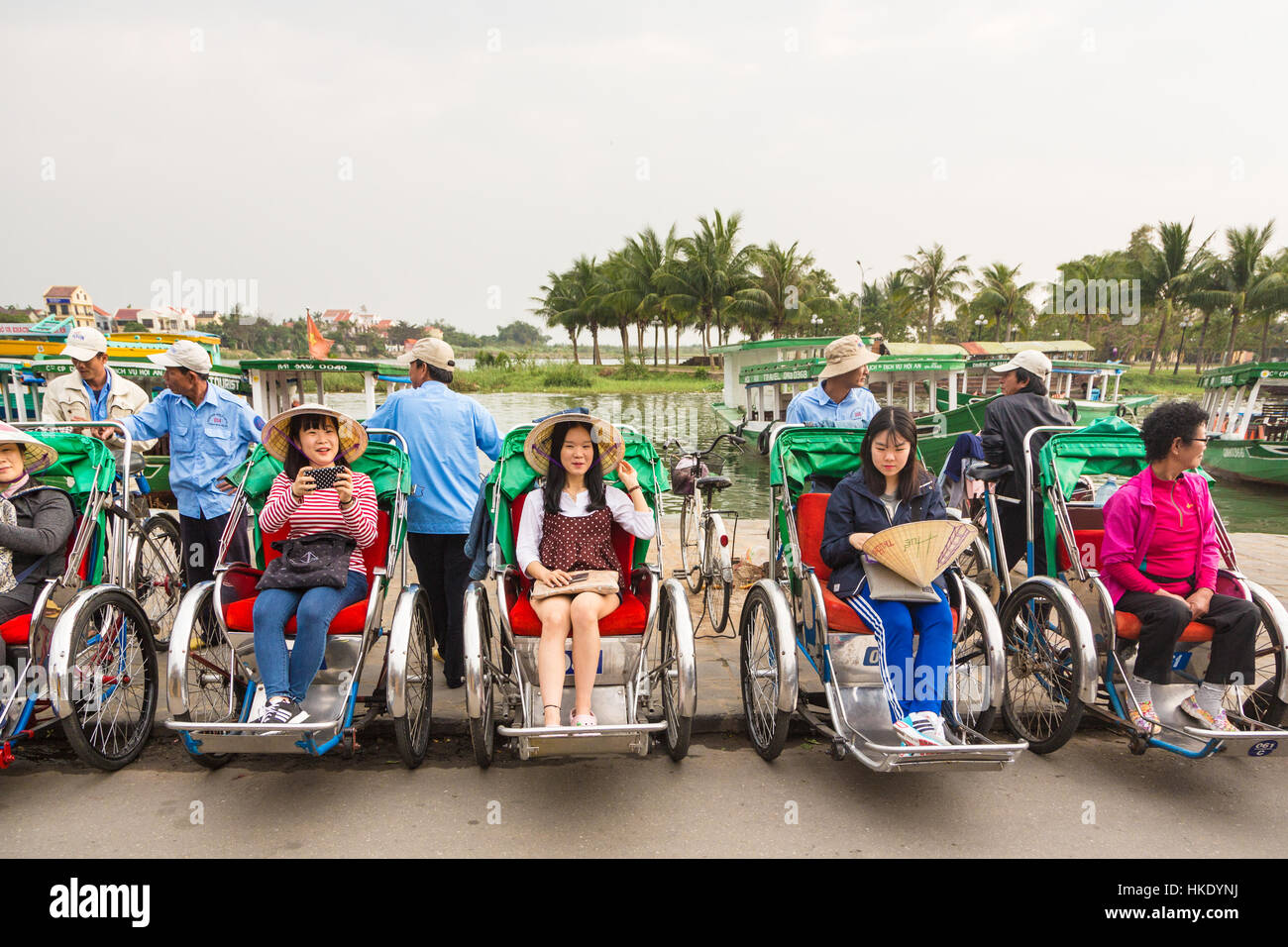 HOI AN, Vietnam - 7 de febrero de 2016: los turistas asiáticos esperan su cyclo tour de la ciudad antigua de Hoi An para comenzar. La ciudad fue un importante centro comercial, incluso Foto de stock