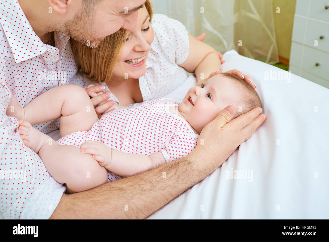 Bebé con sus padres hogar feliz en el sofá. Mamá y papá playi Fotografía de  stock - Alamy