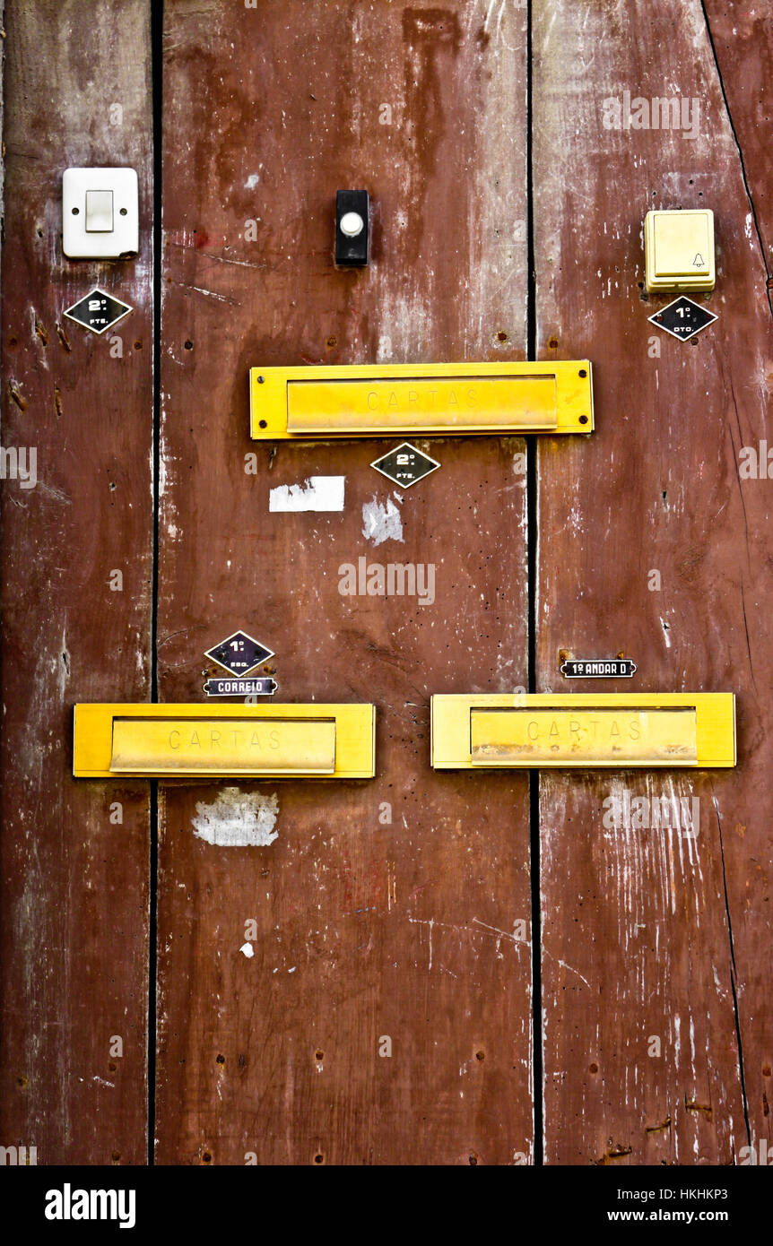 Puerta de madera antigua con timbres y ranuras de expansión en Lisboa Foto de stock