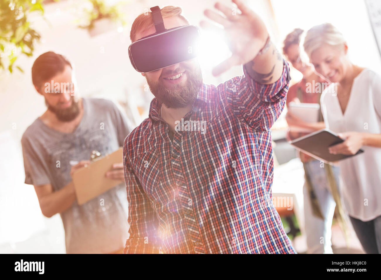 Diseño profesional masculina sonriente con simulador de realidad virtual gafas en reunión Foto de stock