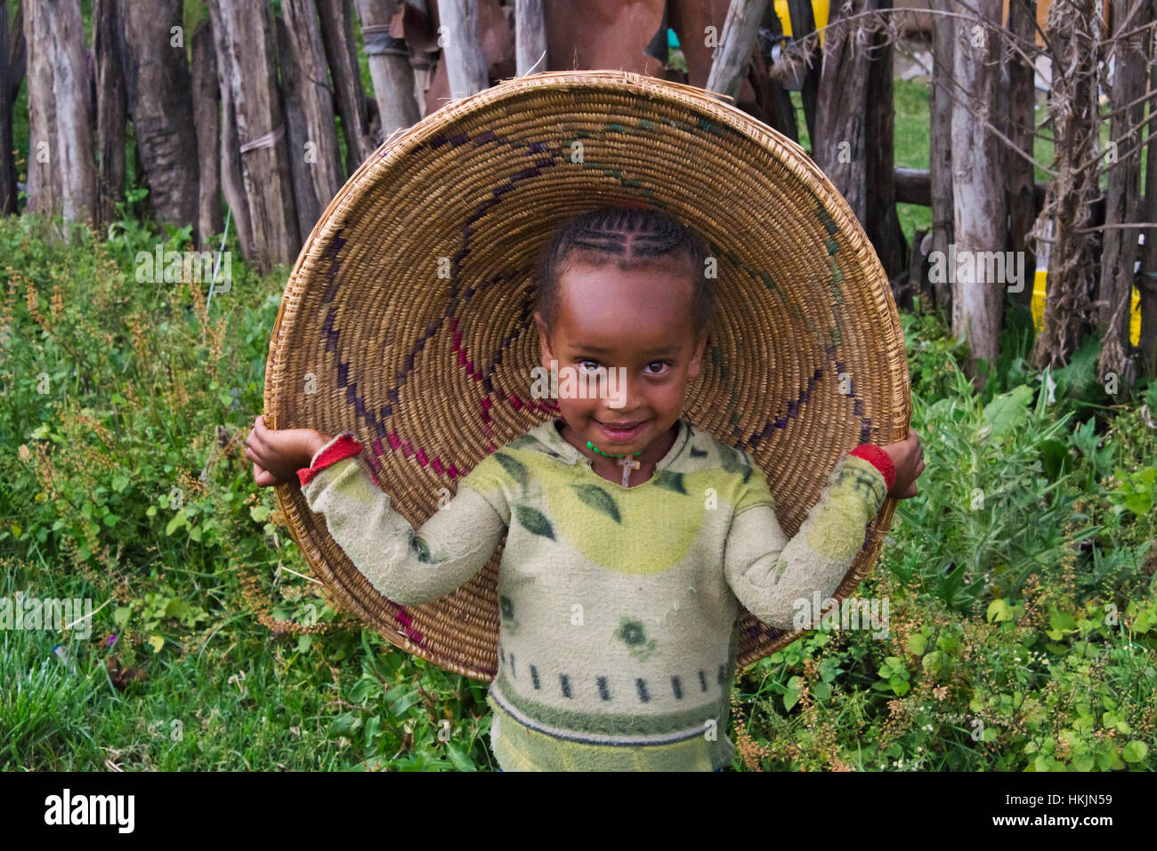 Kid vistiendo la tapa del contenedor de pan plano injera, Addis Ababa, Etiopía Foto de stock