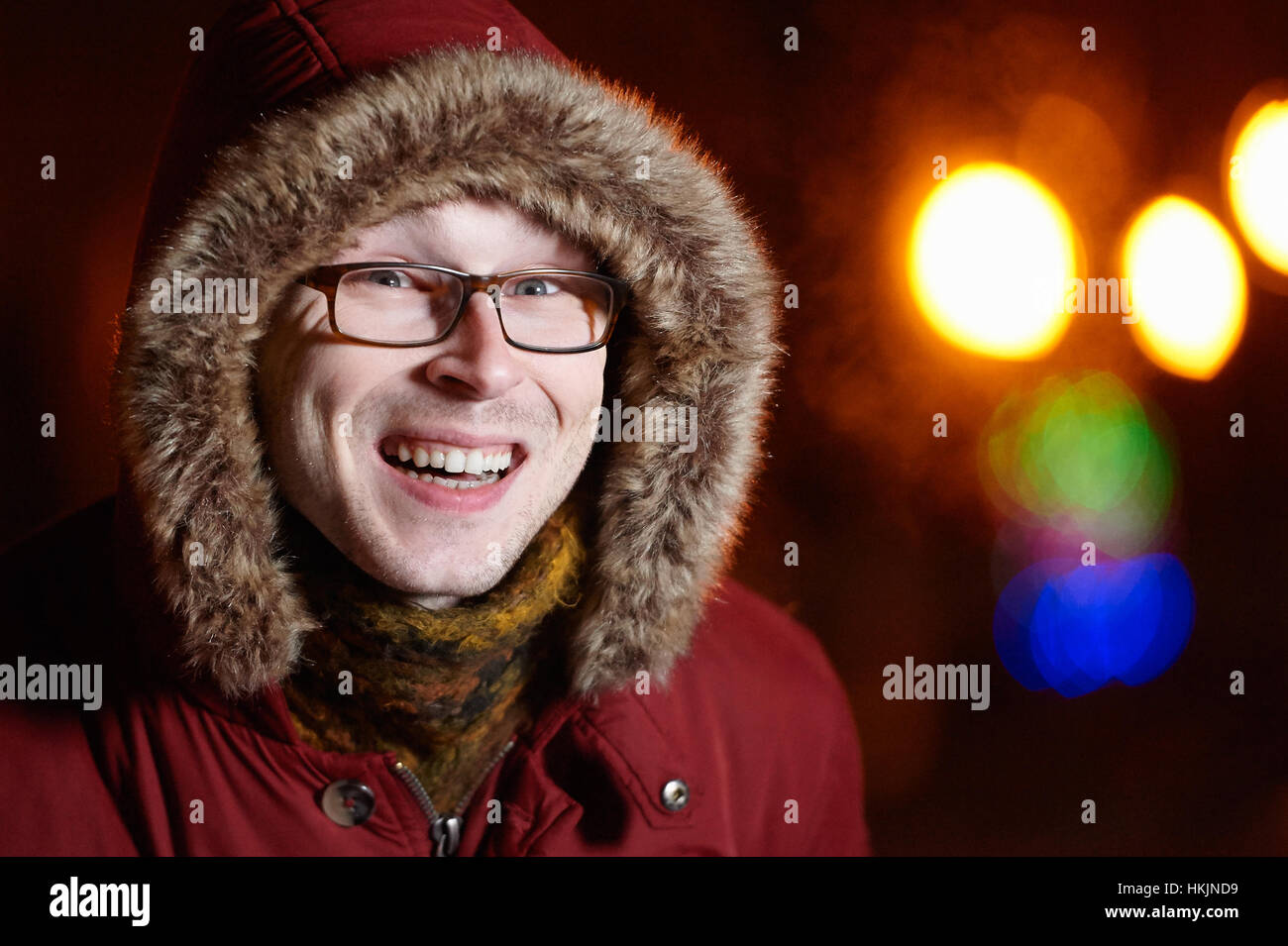Reír Hombre con gafas en invierno chaqueta y bufanda Foto de stock