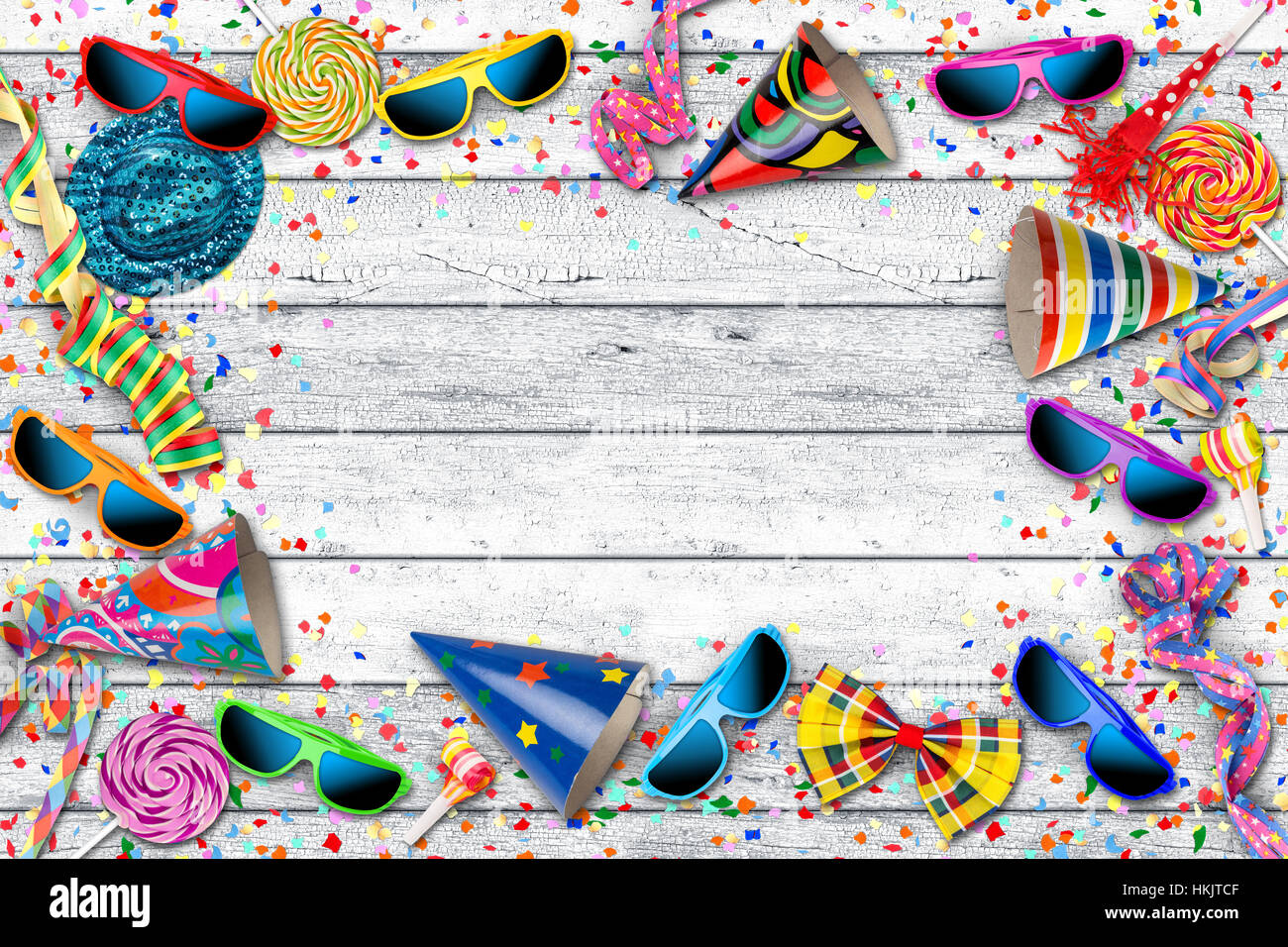 Parte carnaval cumpleaños fondo con coloridas gafas espantapájaros confeti hat piruleta sobre mesa de madera blanca Foto de stock