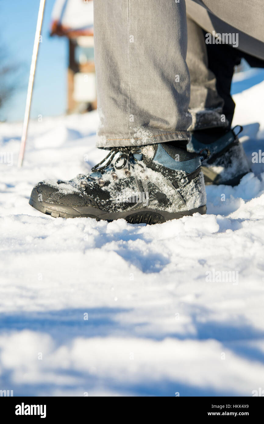 Botas de invierno cubierto de nieve y el bastón de senderismo Foto de stock