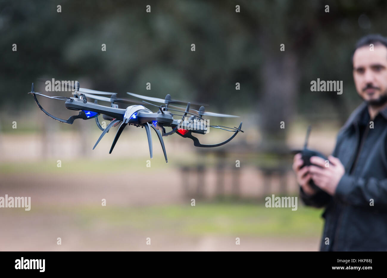 Un hombre operando el Drone por control remoto en el parque Foto de stock
