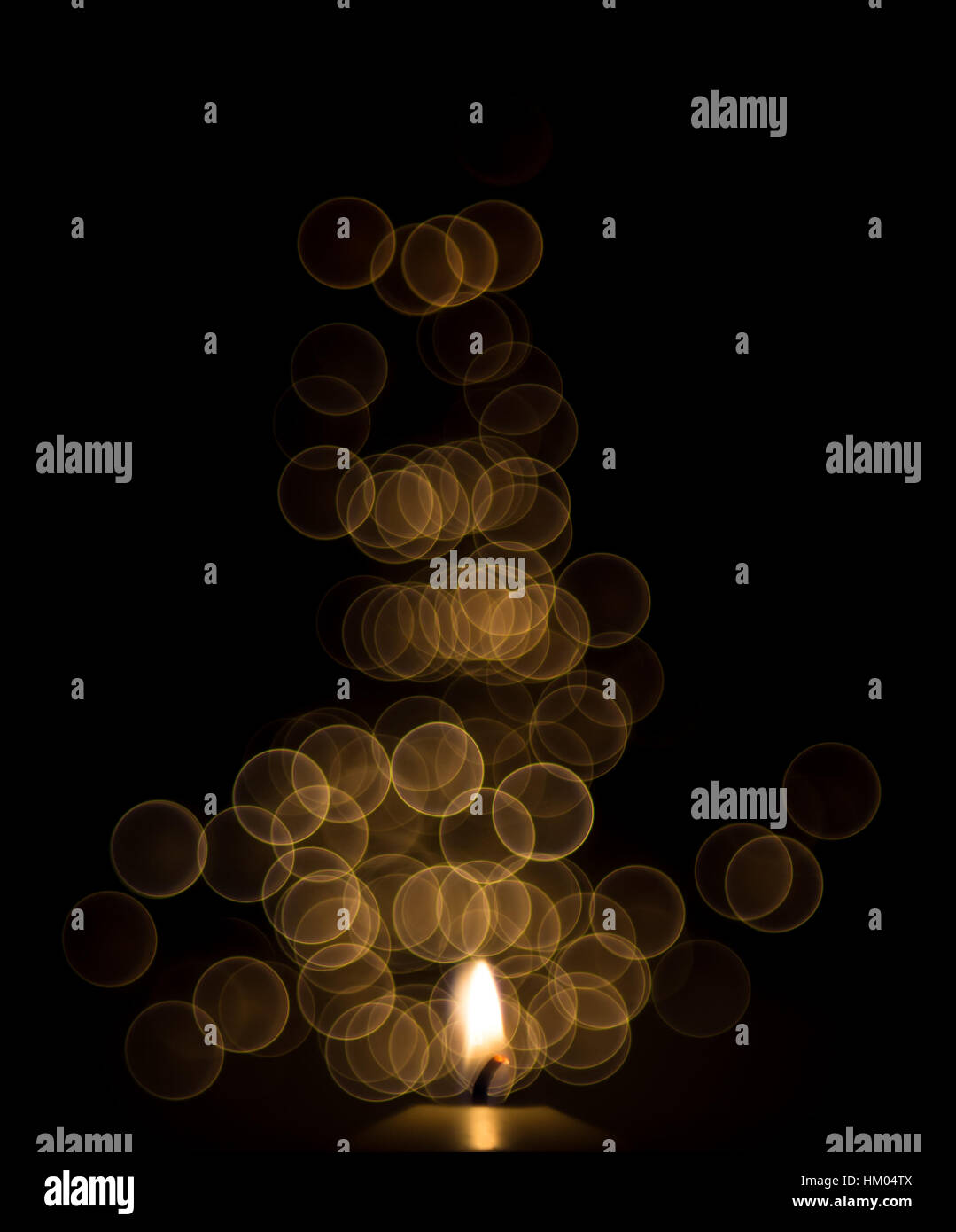 Uno la llama de una vela en la noche con bokeh Foto de stock