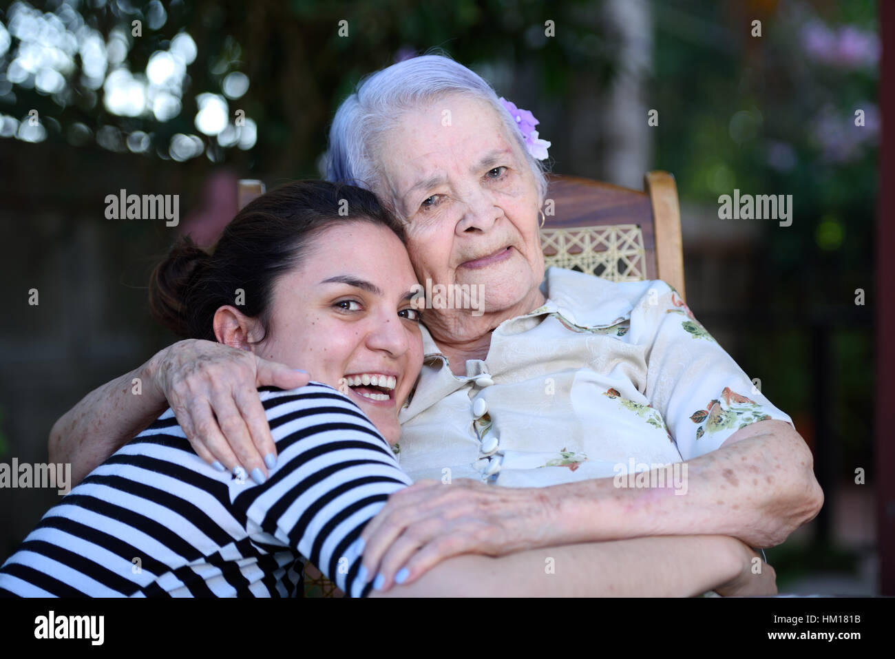 Abuela y nieta sonriendo y abrazando a Foto de stock