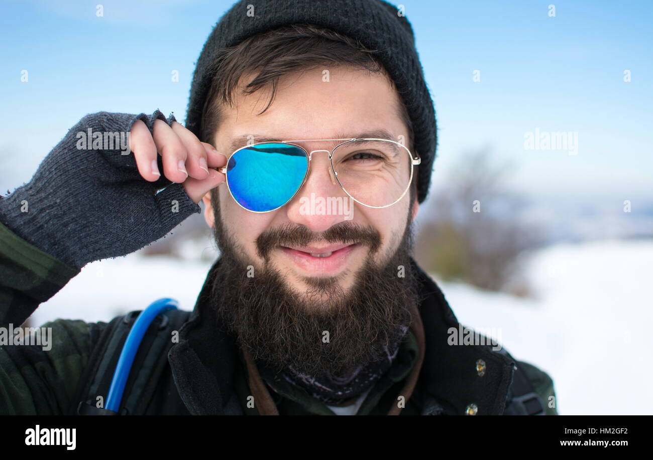 Feliz el hombre barbudo con gafas rotas en el exterior Foto de stock