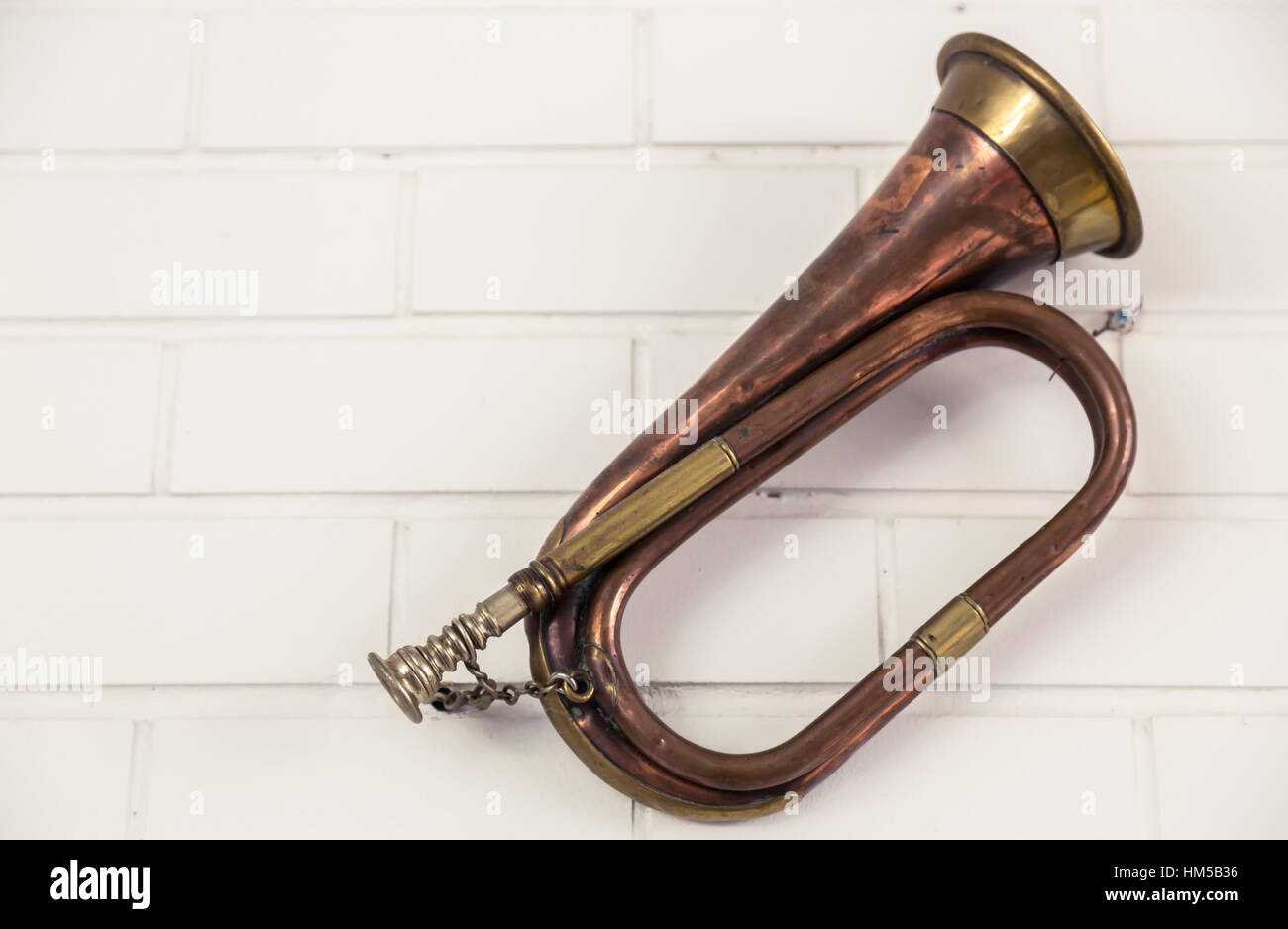 Trompeta antigua colgar en pared de ladrillo Fotografía de stock - Alamy