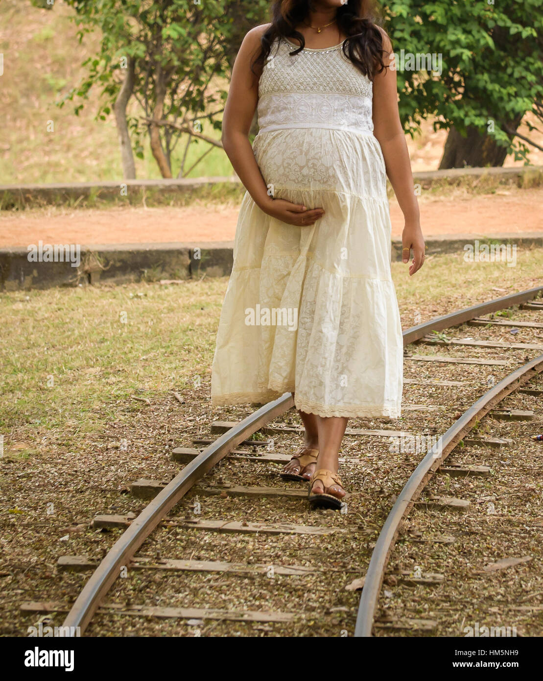 Una mujer embarazada mostrando vientre vistiendo un hermoso vestido de moda Fotografía de stock - Alamy