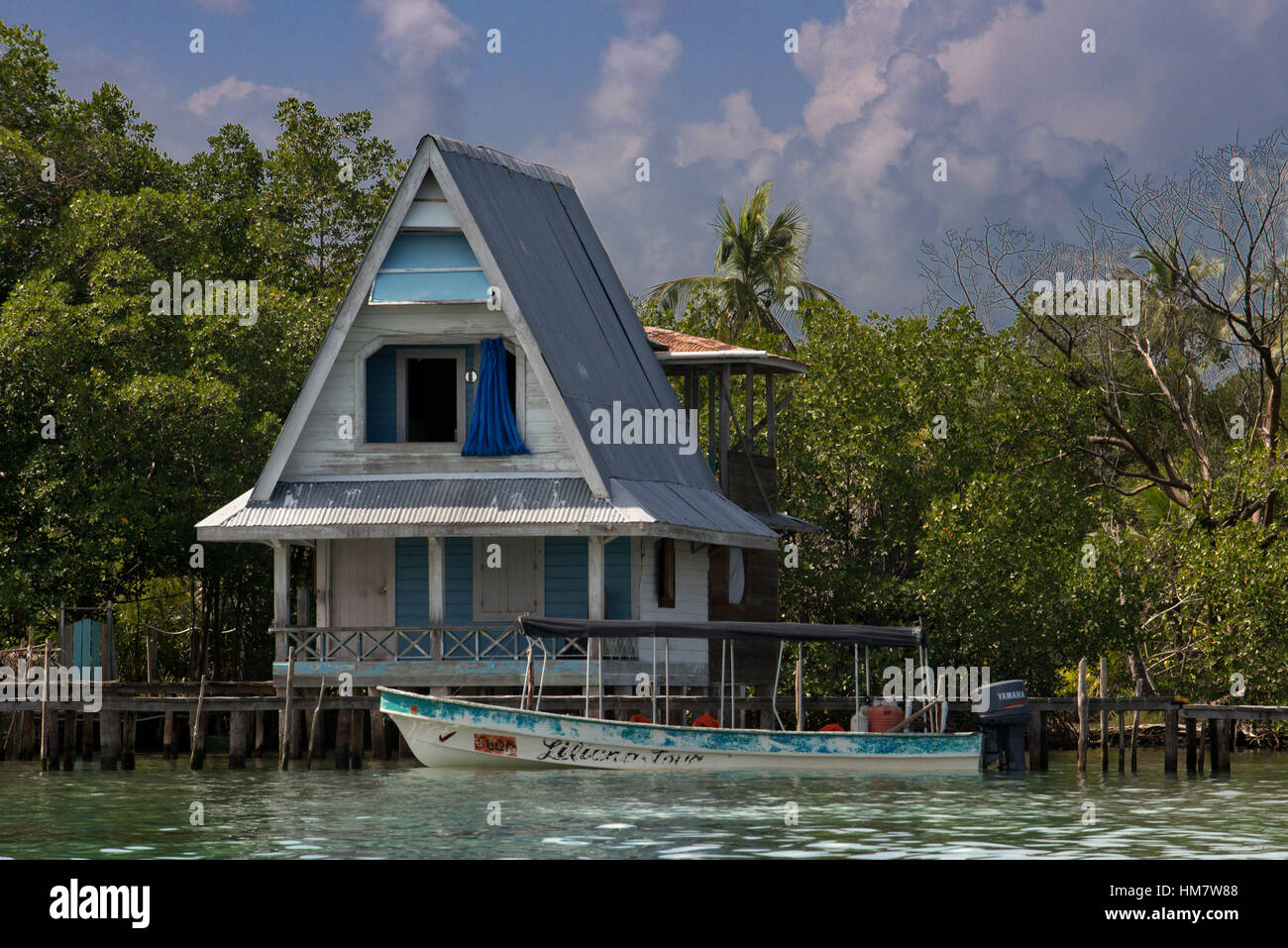 Casa sobre pilotes sobre el agua con paneles solares y densa vegetación tropical en el fondo, Bocas del Toro, mar Caribe, Panamá. Cabaña tropical en t Foto de stock
