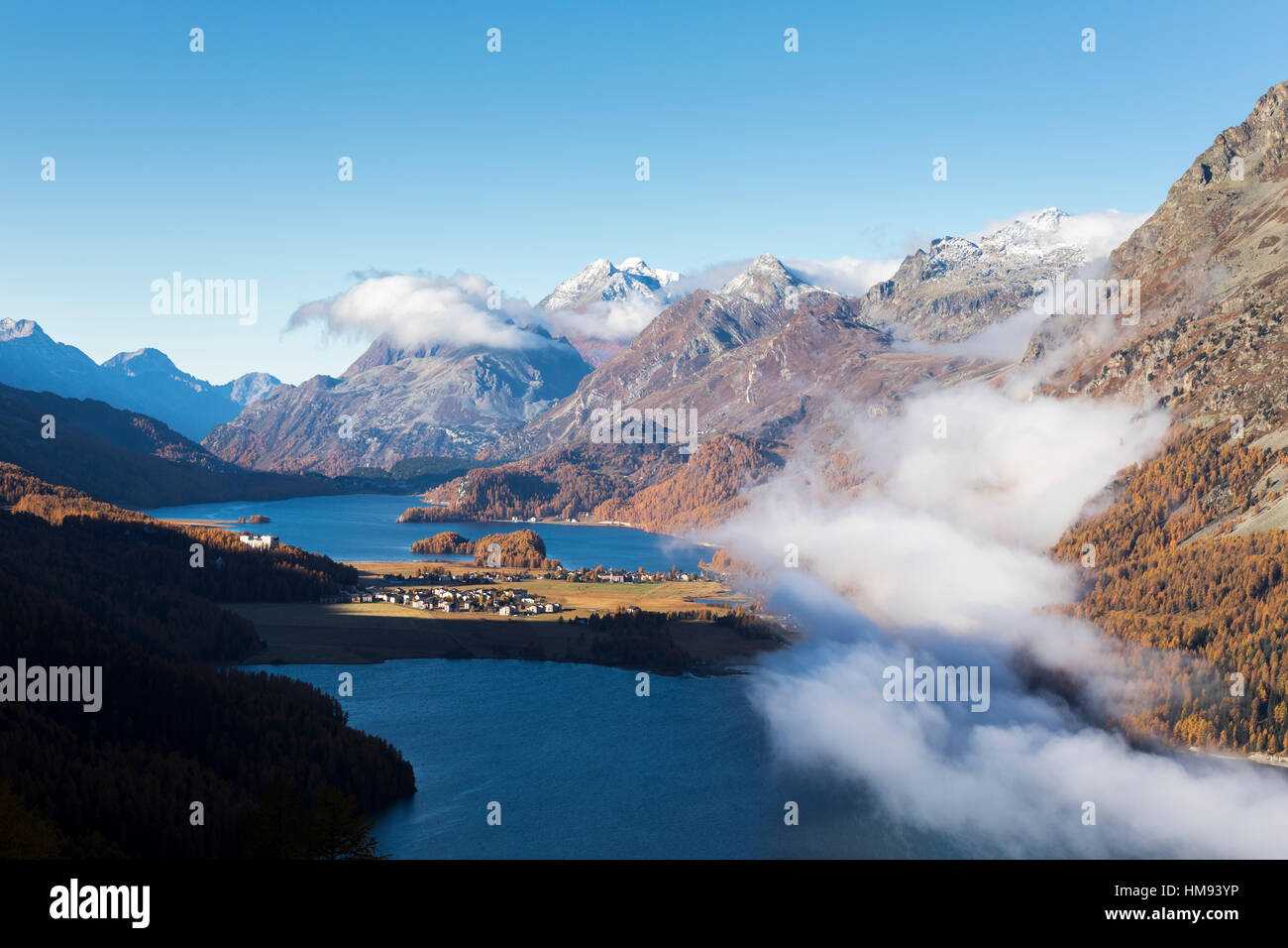 Vista de Sils y el lago azul, rodeado de niebla en otoño, Surlej, St. Moritz, Cantón de Graubunden, Engadin, Suiza Foto de stock