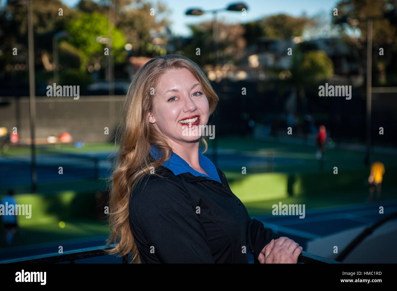Piel justo cabeza roja mujer sonriendo mientras llevaba chaqueta negro atlético. Foto de stock
