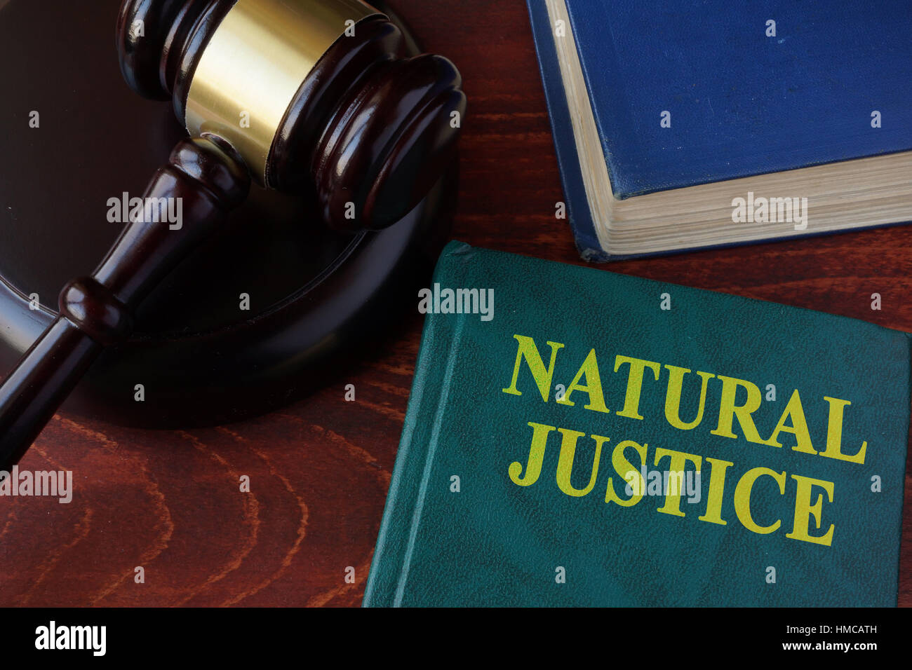 Libro con el título de la justicia natural y martillo. Foto de stock