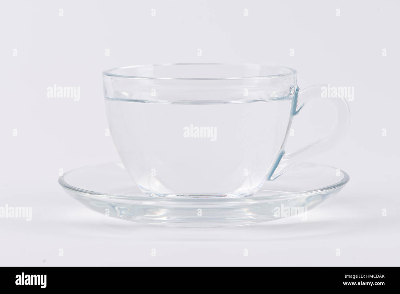 Una taza de agua clara sobre fondo blanco. Foto de stock