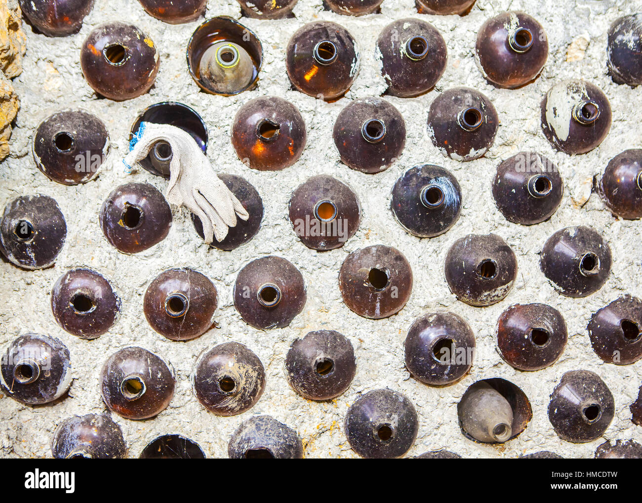 Galón botellas de vidrio utilizados para construir una casa de pared de botella. Foto de stock