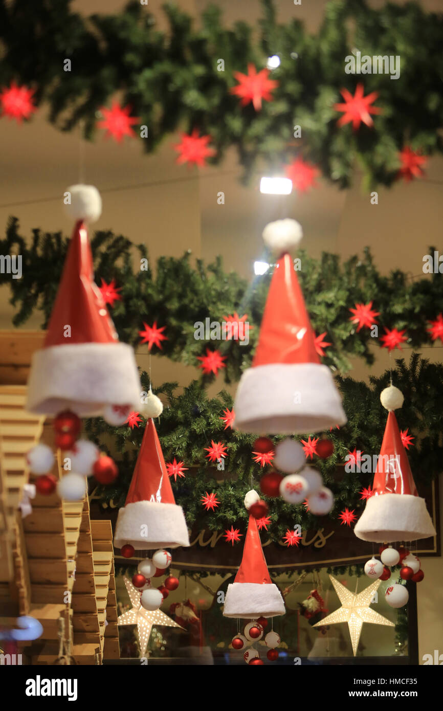 Los capots du Père Noël suspendus de cadeaux dans une boutique. Foto de stock