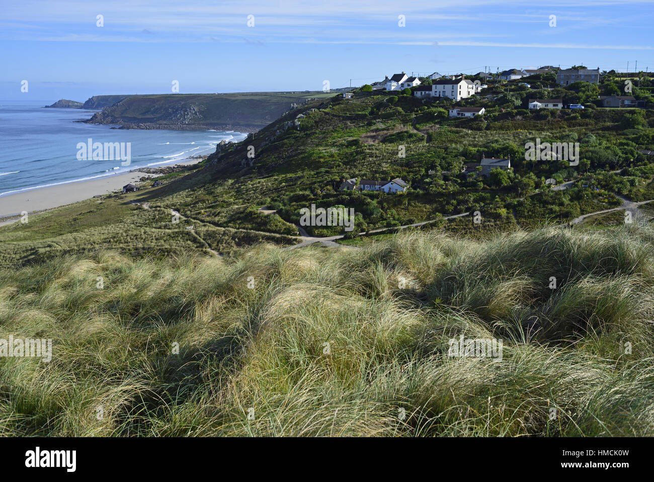 Dunas cubiertas de hierba Marram anteriormente Sennen Whitesand Bay, Cornwall, con las casas de Towan Carn y Cornwall en la distancia Foto de stock