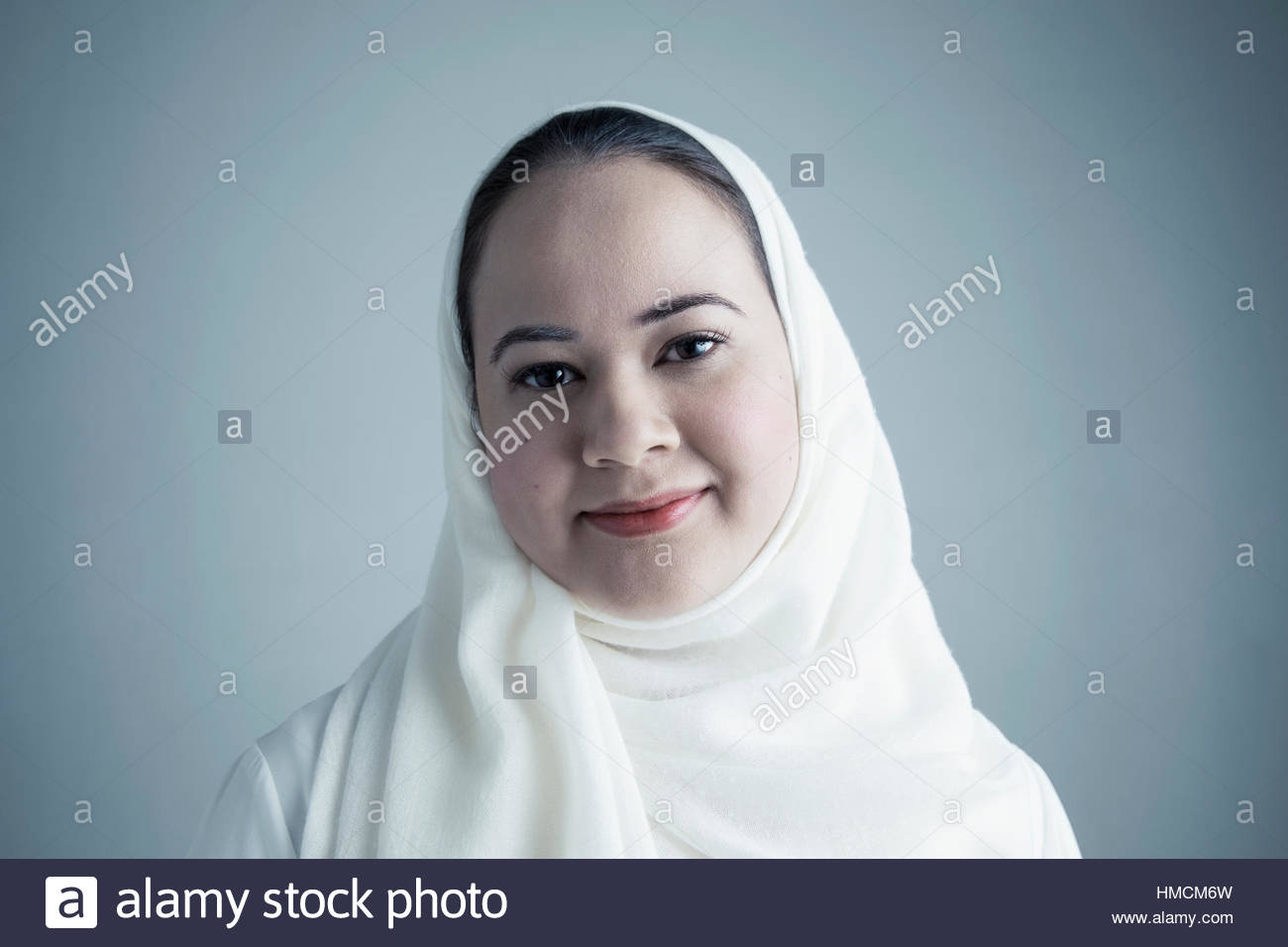 Retrato de Oriente Medio sonriente joven mujer vestidos de blanco pañuelo Foto de stock