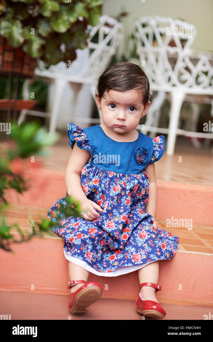 Una pequeña niña niño sentarse en pasos de vestir Foto de stock