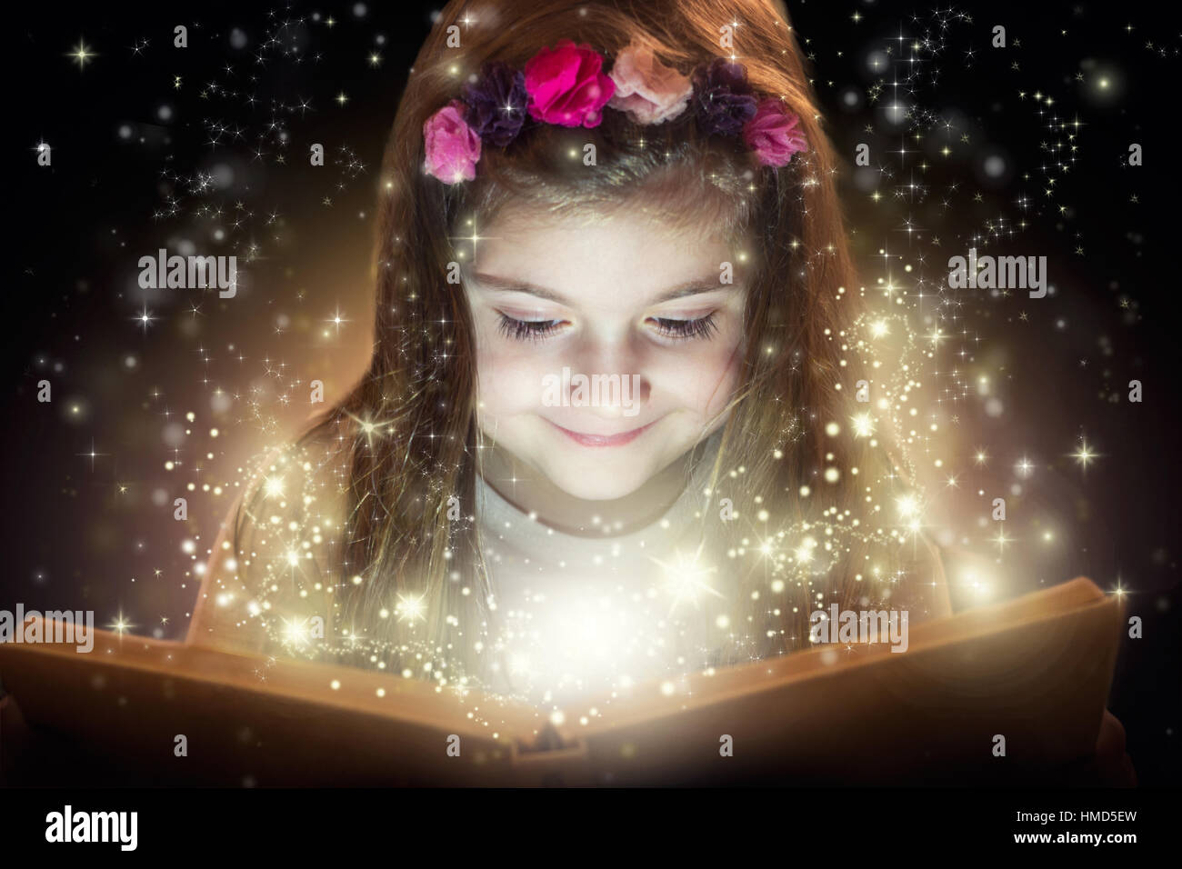 Niña leyendo libro mágico, concepto de fantasía Foto de stock