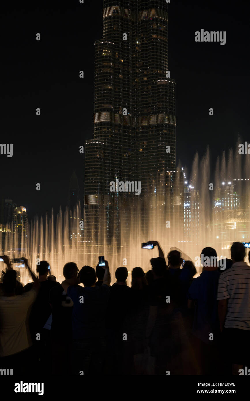 Los turistas tomando una instantánea en su smartphone de Burj Dubai, un espectáculo de luz. Emiratos Arabes Unidos Foto de stock