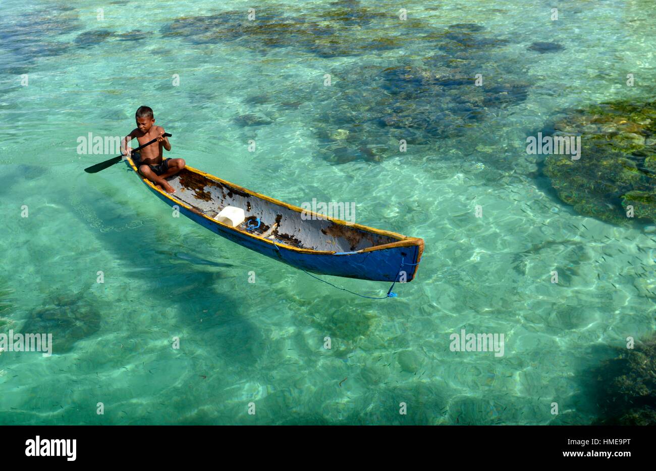 Un joven en un bote de remos, Raja Empat islas,provincia de Papúa Occidental, Indonesia oriental. Foto de stock