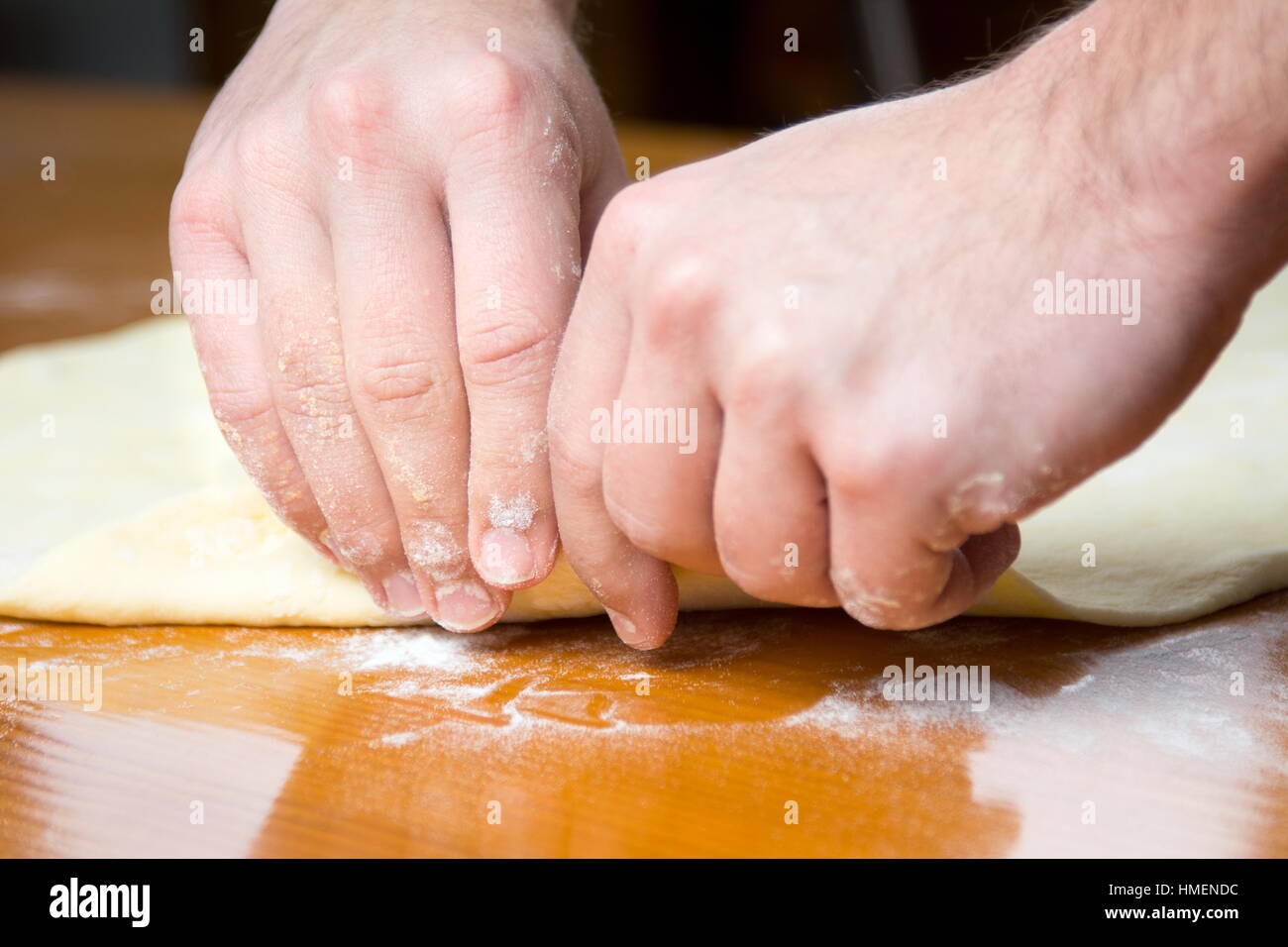 Baker macho extendiendo la masa para hacer pizza Foto de stock