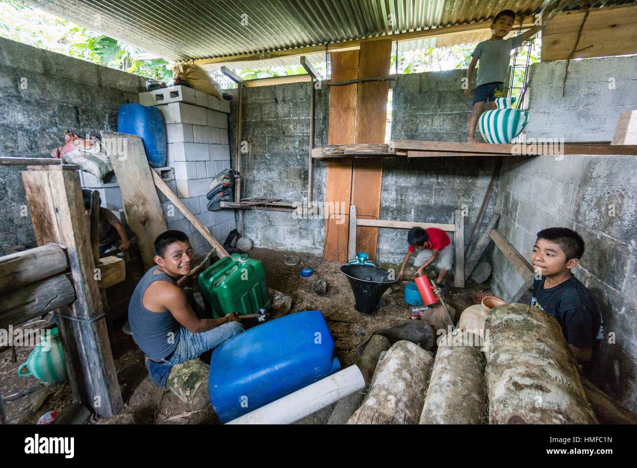 Niños tocando percusión con latas de plastico, La Taña, zona Reyna, departamento de Uspantan, Guatemala, América Central. Foto de stock
